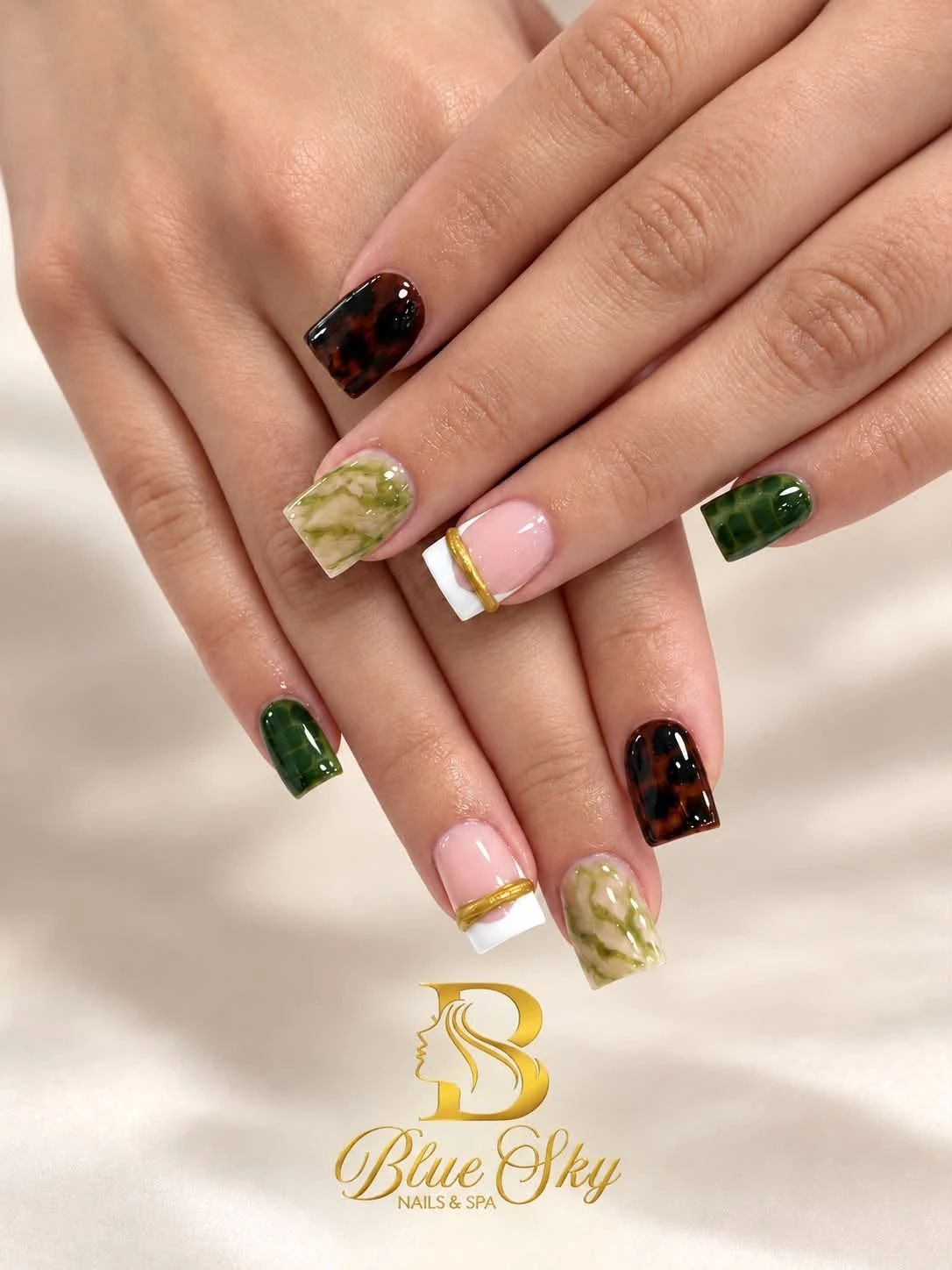 Square nails with olive marble, tortoiseshell designs and gold-accented French tips