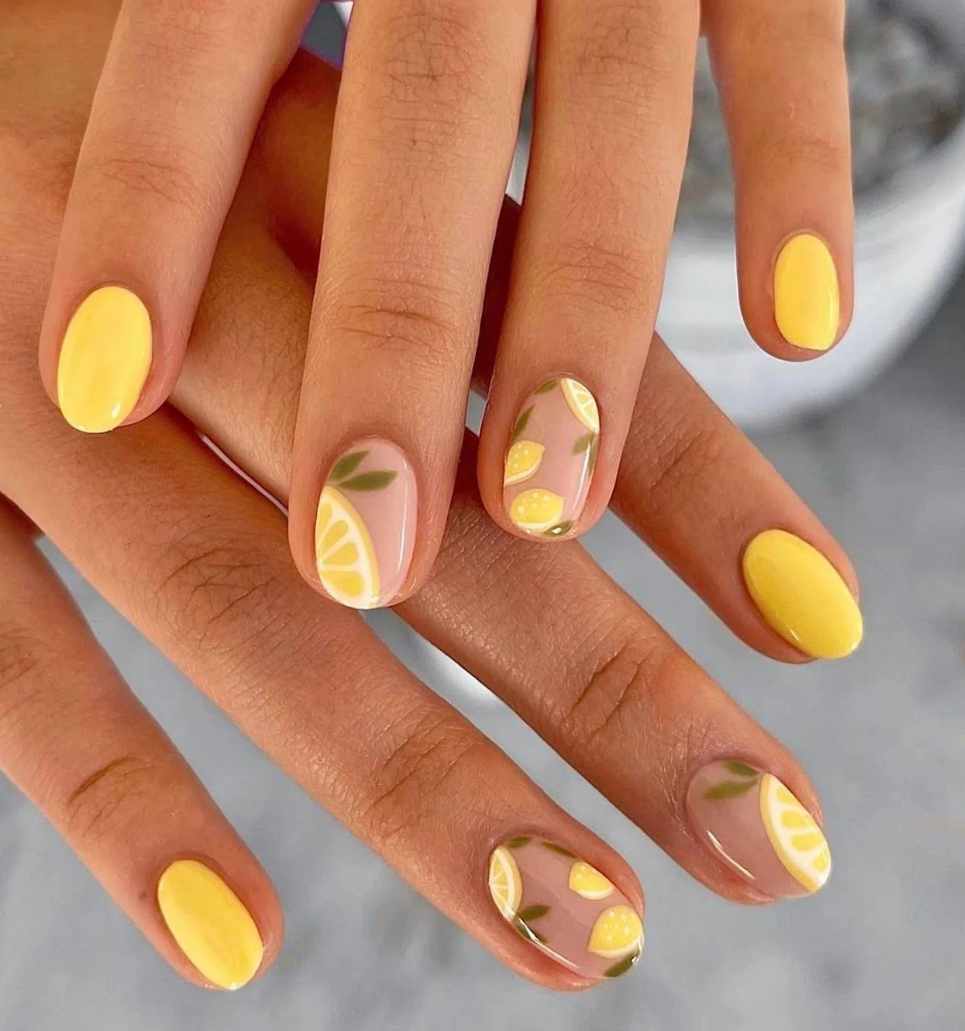 Yellow and nude nails with hand-painted lemon and leaf designs