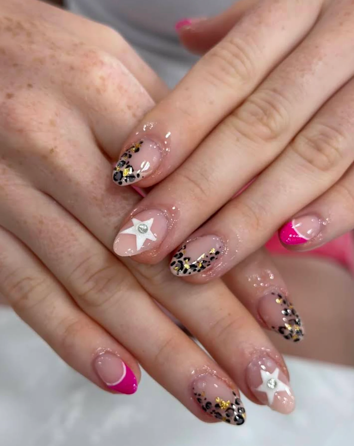 Nude and pink nails with leopard accents, white stars and small gems