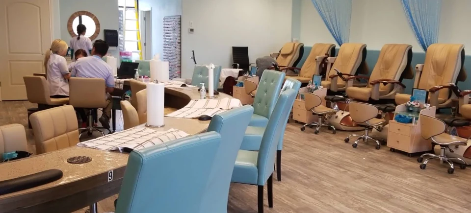 Wide salon view with manicure stations and pedicure chairs